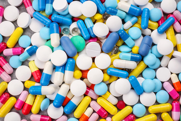 Various colored pills and capsules spread out on a table, representing a diverse selection of medication options.