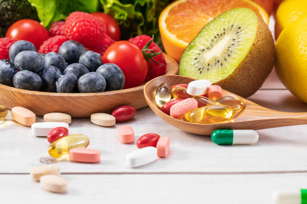 Various vitamins and supplements neatly arranged on a wooden table.